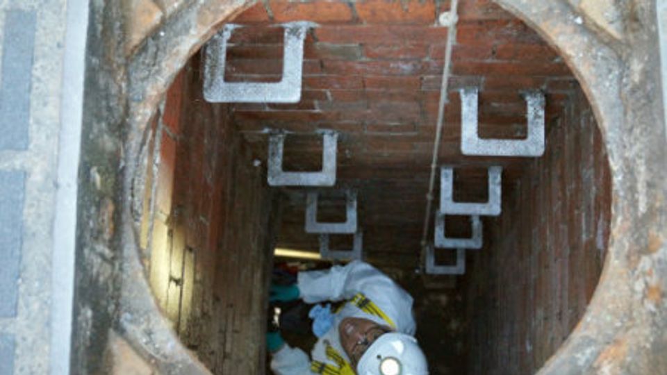Worker climbs into a sewer
