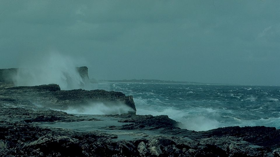 Waves crashing over rocks during storm