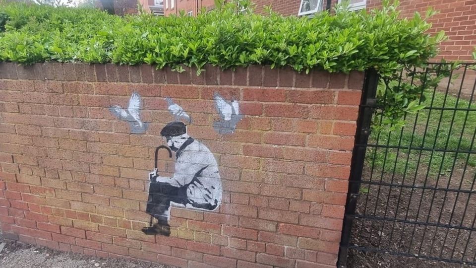 Mural of an elderly man with a cane and flat cap and a trio of pigeons