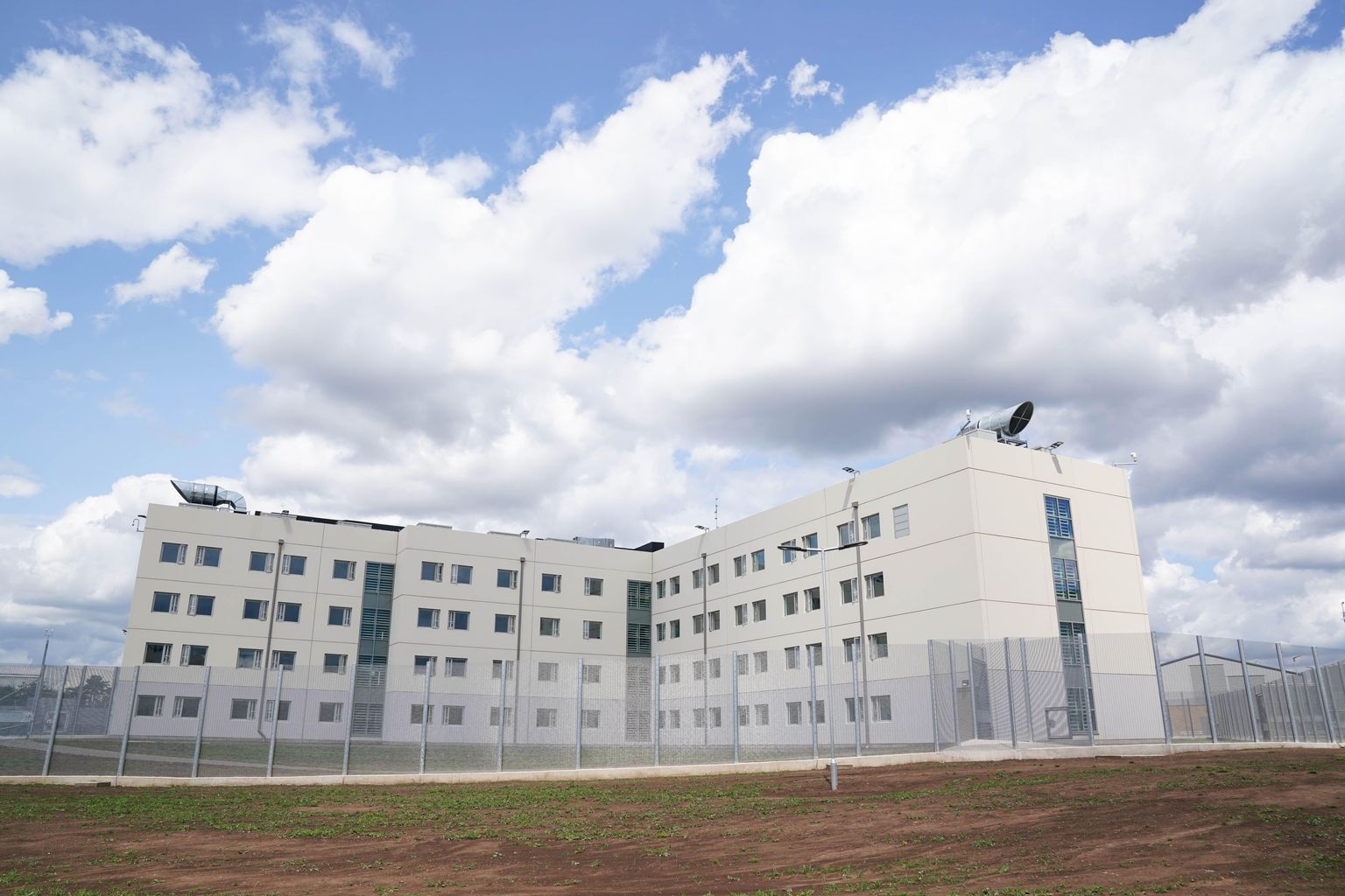 HMP Fosse Way from outside- white building, four floors of square windows