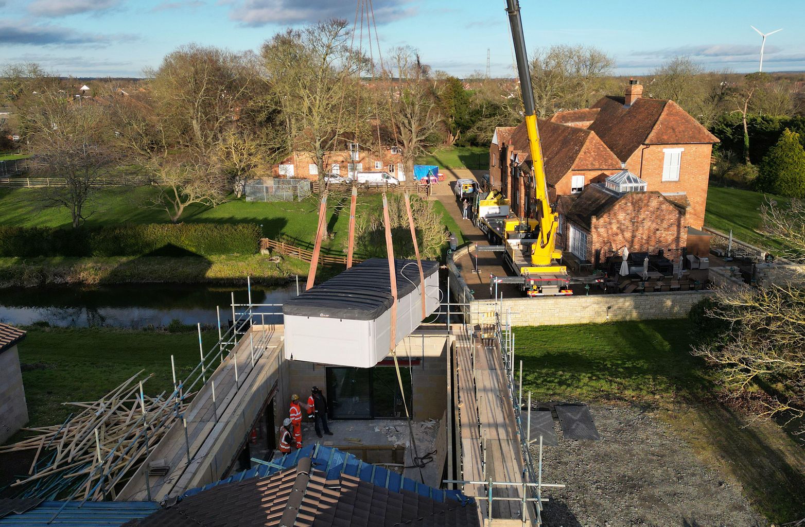 Crane lifts pool out of spa block at home of Captain Tom's family