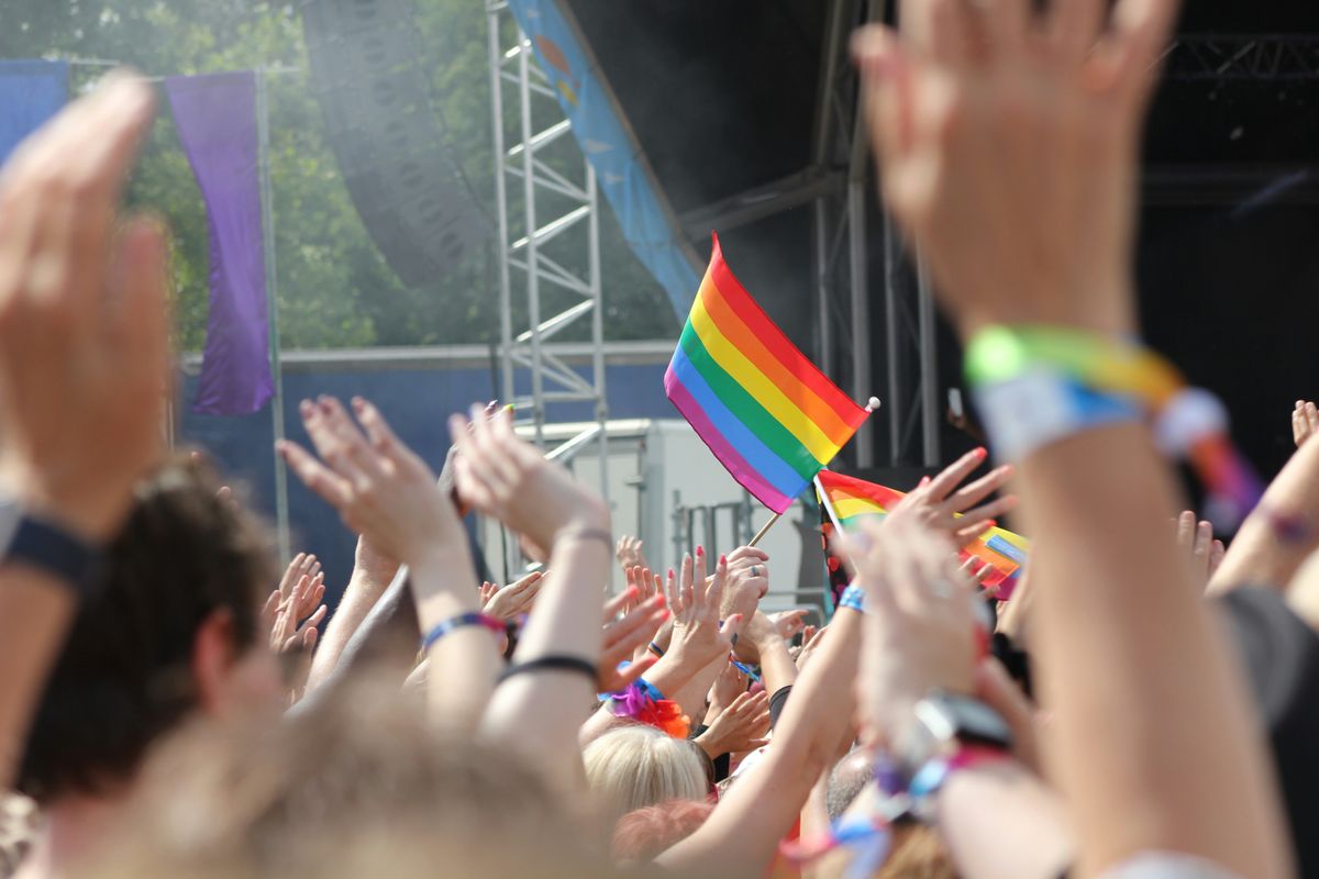 Rainbow flags flying high against a clear blue sky